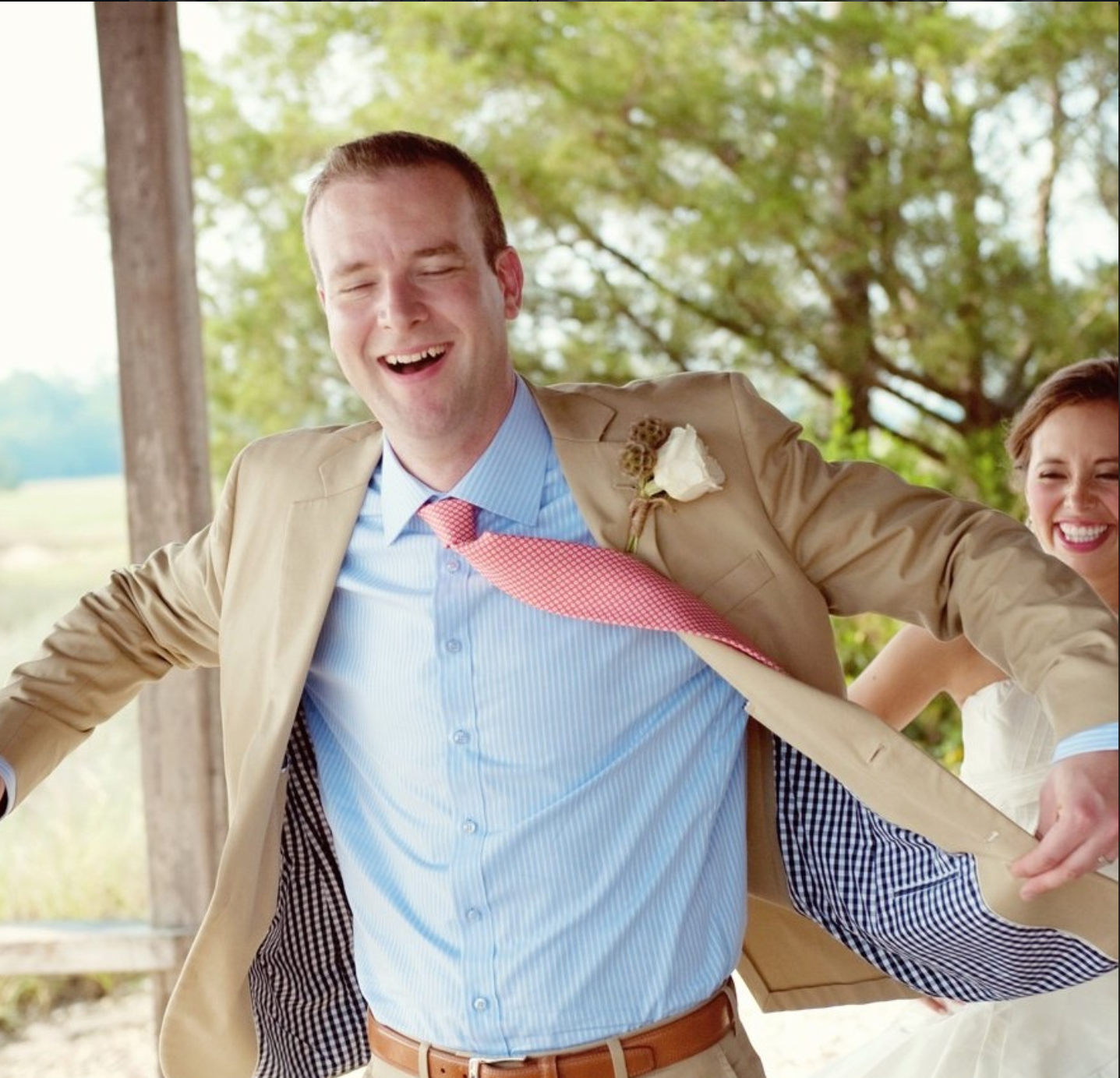 Groom laughing at an outdoor wedding cooled by All-Mist